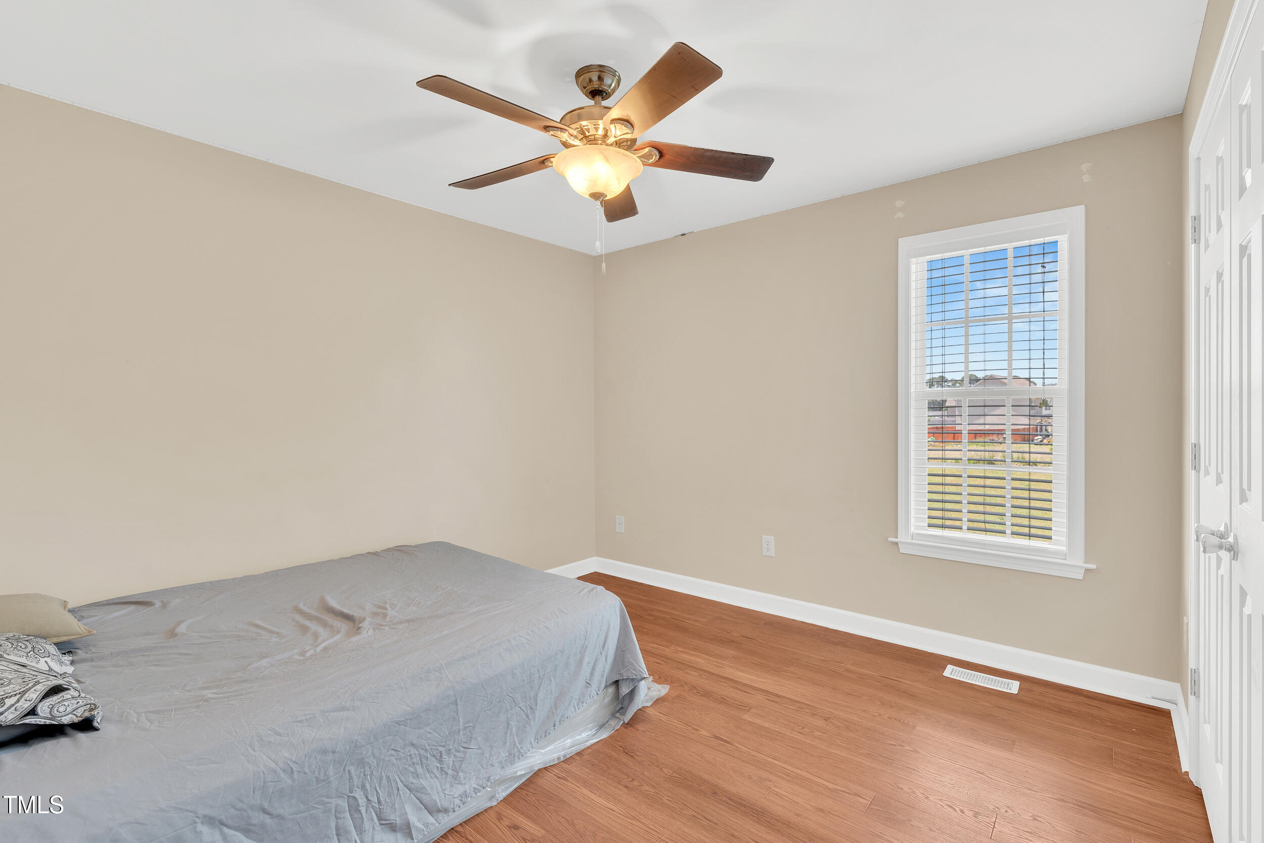 104 JJ Drive Benson, NC 27504 - Photo 6 of 20 an empty room with a window and a ceiling fan