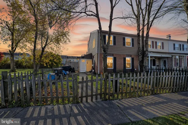 a view of a brick house with large windows and a small yard