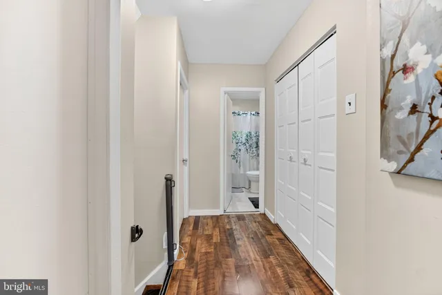 a view of a hallway with wooden floor and staircase