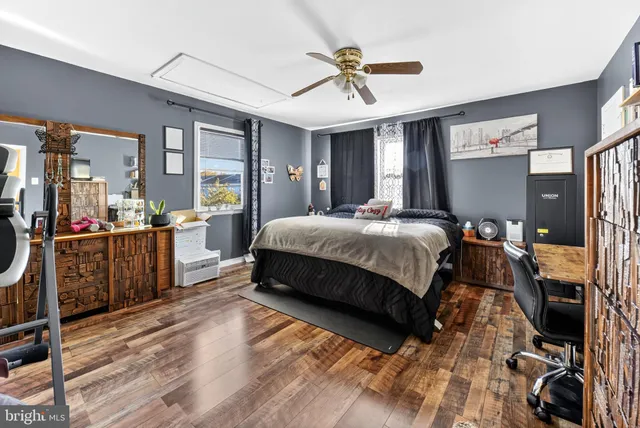 a spacious bedroom with a bed a dresser and large mirror