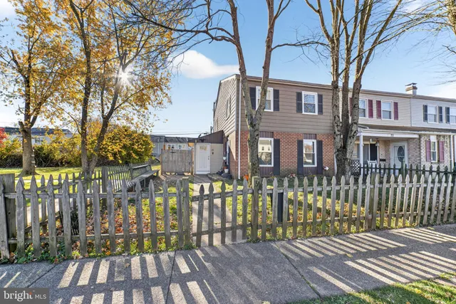 a view of a brick house with a large trees