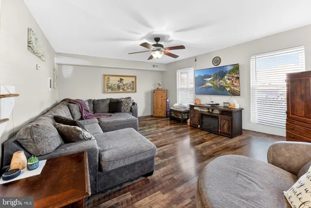 a living room with furniture ceiling fan and a window