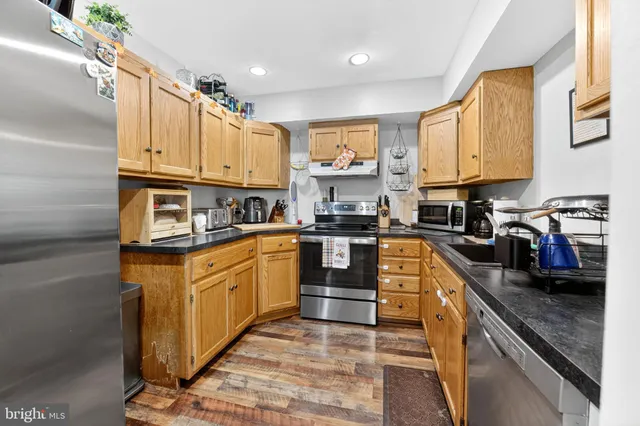 a kitchen with stainless steel appliances granite countertop a stove a sink and a refrigerator