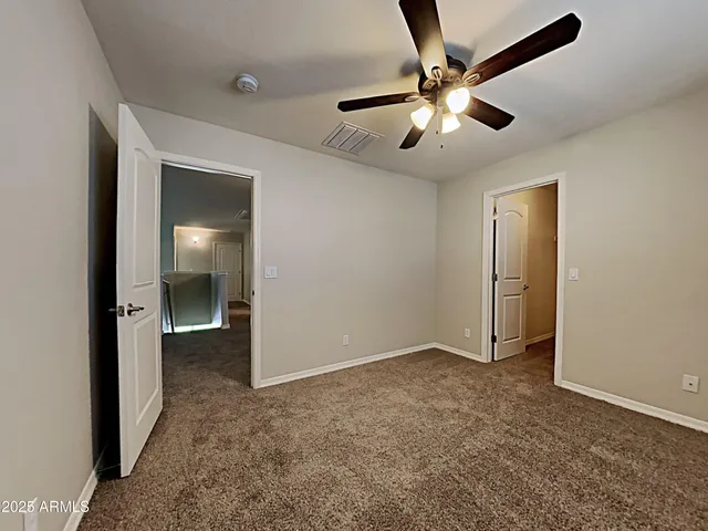 wooden floor in an empty room and a ceiling fan