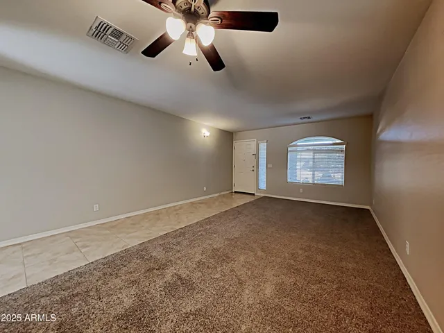 en empty room with windows and fan