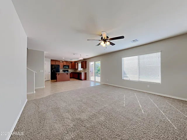 a view of empty room with a kitchen