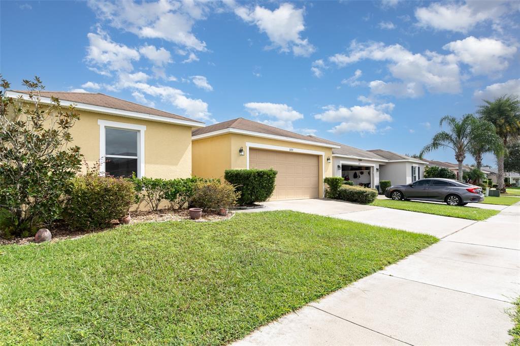 5100 Ballark Street Mount Dora, FL 32757 - Photo 2 of 28 a front view of a house with a yard and garage