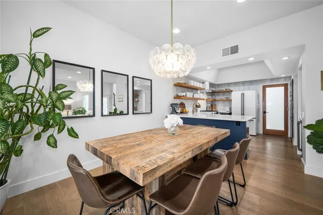 a view of a dining room with furniture a chandelier and wooden floor