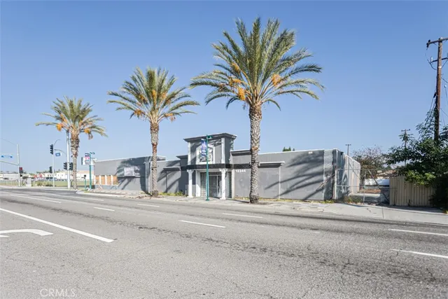 a row of palm trees and a swimming pool on the side of the house