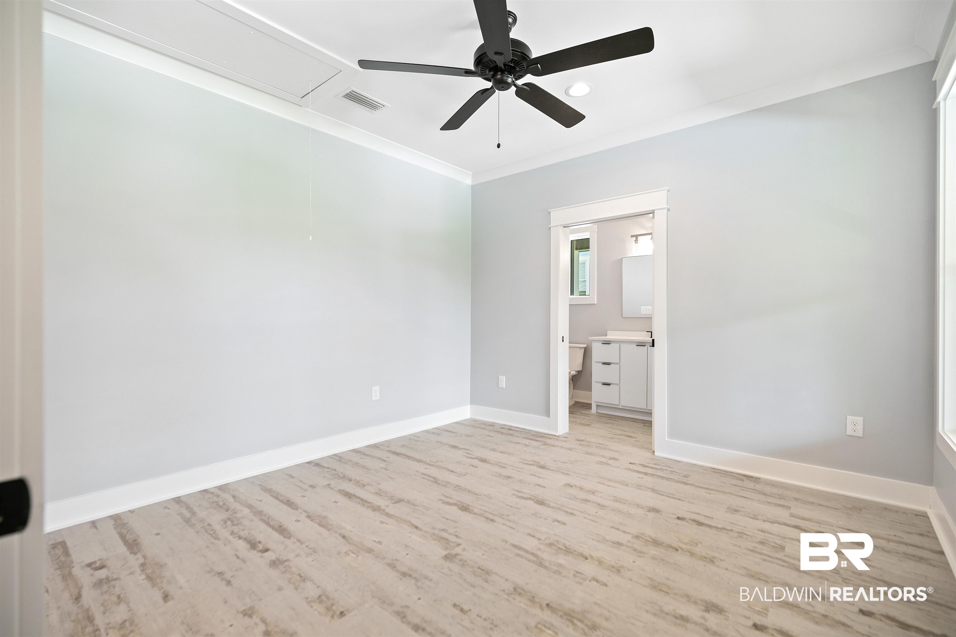 10507 County Road 1 Fairhope, AL 36532 - Photo 21 of 59 Unfurnished bedroom with light hardwood / wood-style flooring, ensuite bath, ceiling fan, and crown molding