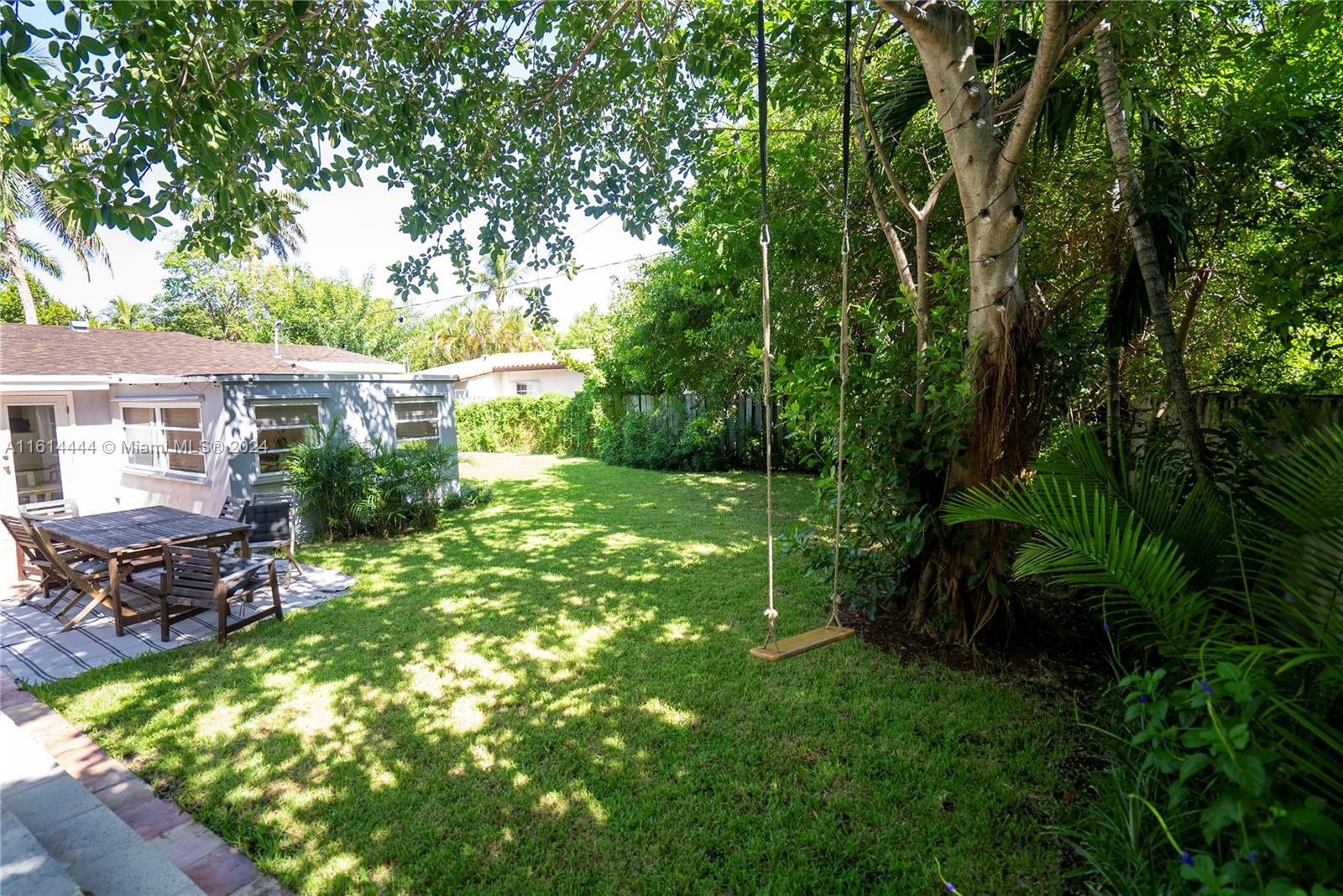 785 Fernwood Road Key Biscayne, FL 33149 - Photo 15 of 44 a view of backyard with table and chairs and potted plants
