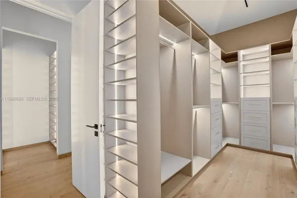 a view of walk in closet with empty racks