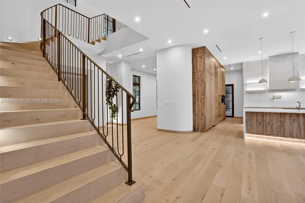 a view of a hallway with wooden floor and stairs