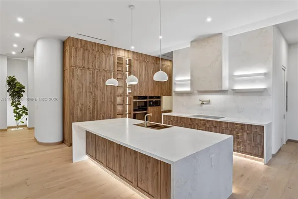 a kitchen with kitchen island a counter top space a sink stainless steel appliances and cabinets