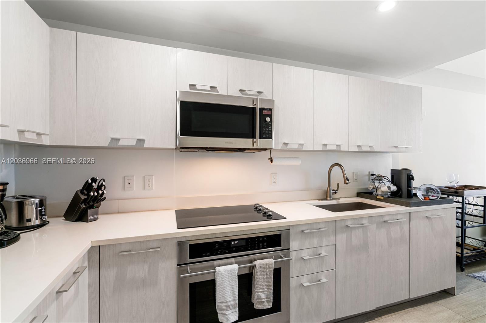 55 Southwest 9th Street, Unit 1904 Miami, FL 33130 - Photo 4 of 66 a kitchen with stainless steel appliances granite countertop a sink a stove a microwave and cabinets