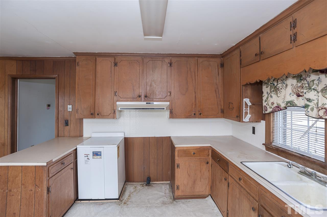 199 West Strickland Road Dunn, NC 28334 - Photo 22 of 25 a kitchen with a sink dishwasher stove and white cabinets