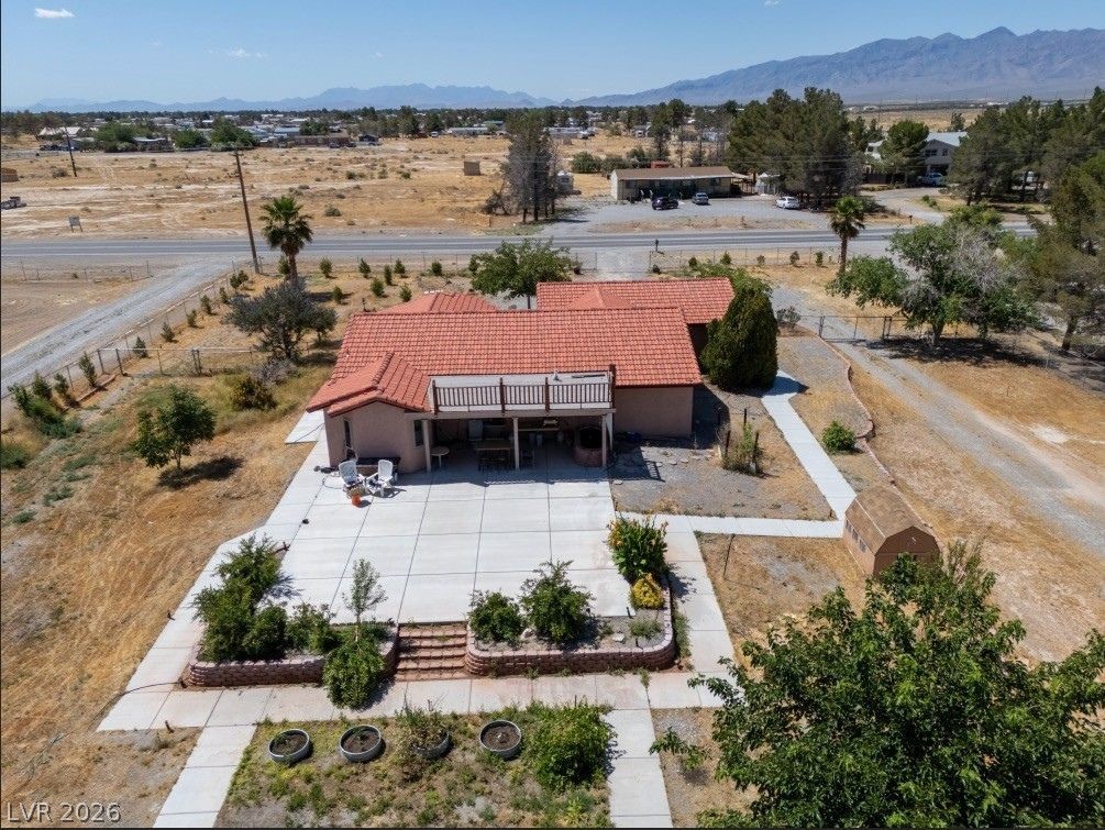 1220 East Gamebird Road Pahrump, NV 89048 - Photo 46 of 49 An aerial perspective reveals the property with its red tile roof, patio area, and distant mountain vistas.