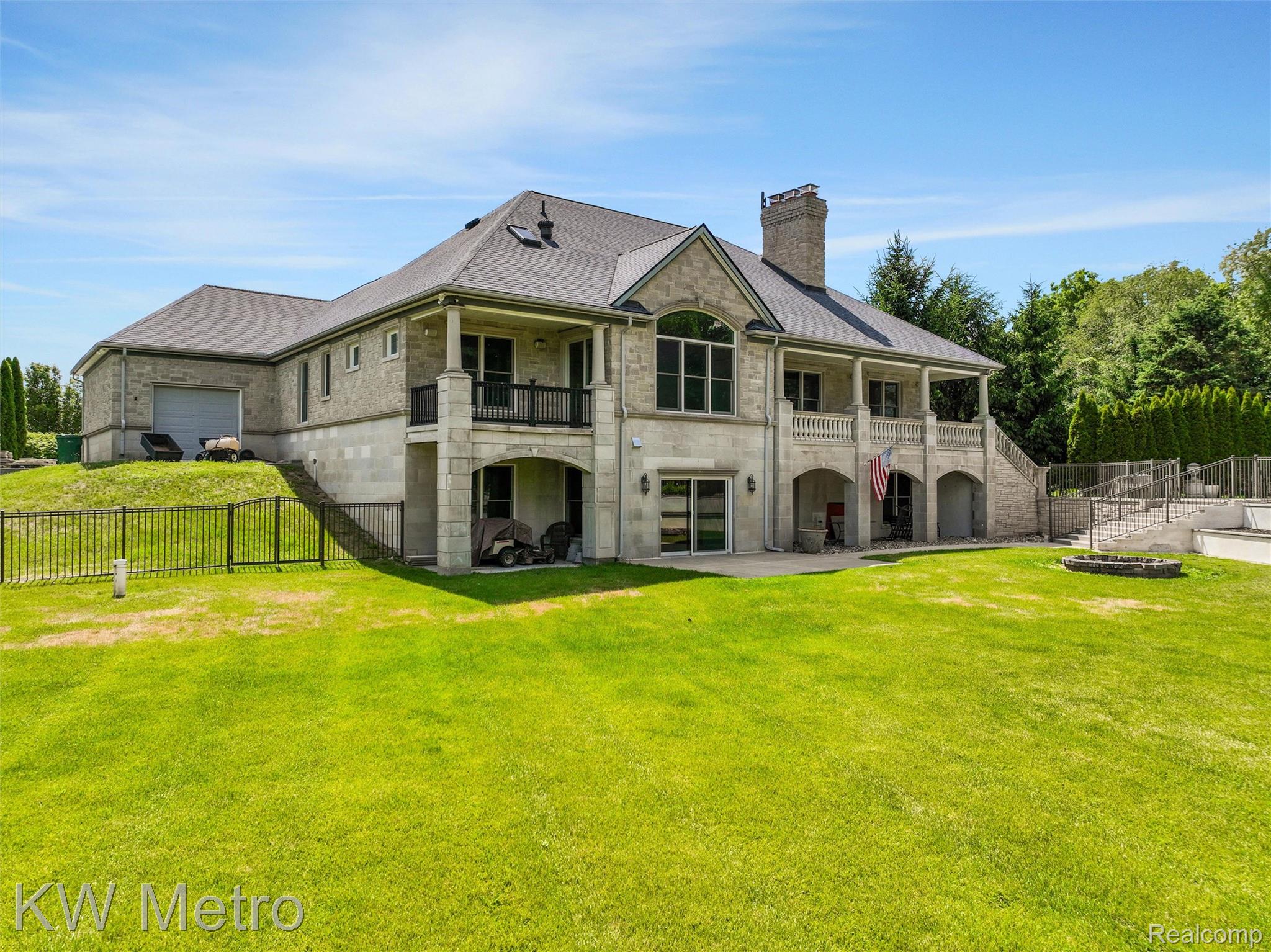 65884 Windrose Court Ray, MI 48096 - Photo 10 of 82 Stone exterior residence featuring a multi-level structure with covered patios and balconies