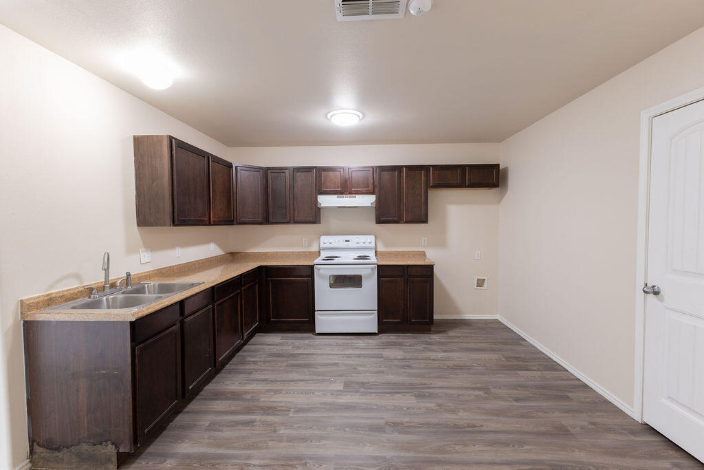 8907 Terrell Avenue Lubbock, TX 79423 - Photo 3 of 8 a large kitchen with stainless steel appliances granite countertop a large counter top a sink and a stove