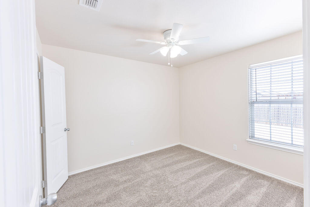 8907 Terrell Avenue Lubbock, TX 79423 - Photo 6 of 8 an empty room with a window and a fan