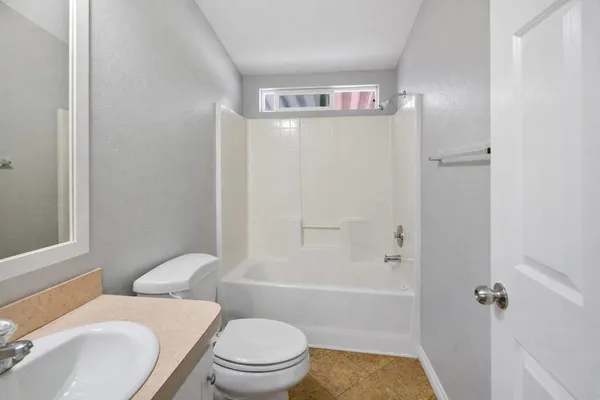 a white toilet sitting next to a bath tub