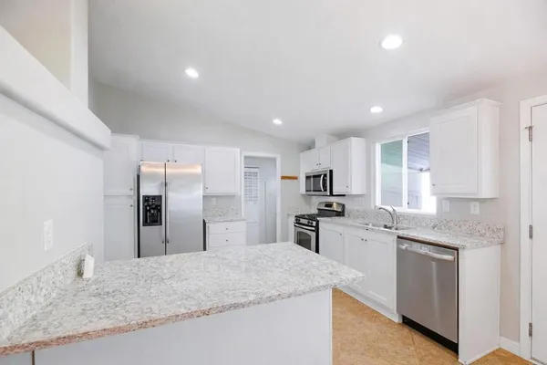 a kitchen with stainless steel appliances granite countertop a sink stove and refrigerator