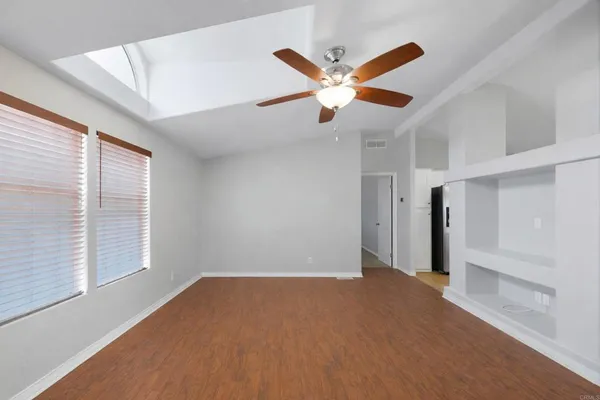 a view of a big room with wooden floor and windows in a room