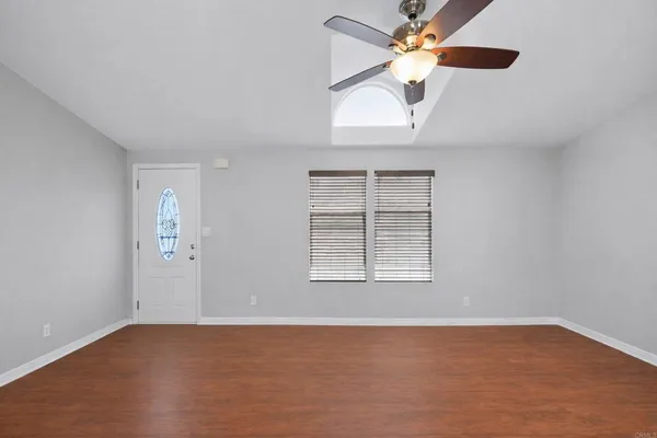 an empty room with windows and fan