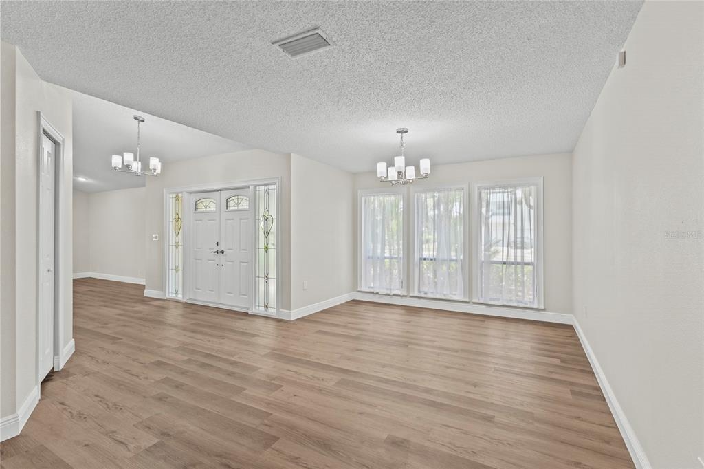 4415 Marine Parkway New Port Richey, FL 34652 - Photo 17 of 72 a view of an empty room with wooden floor and chandelier