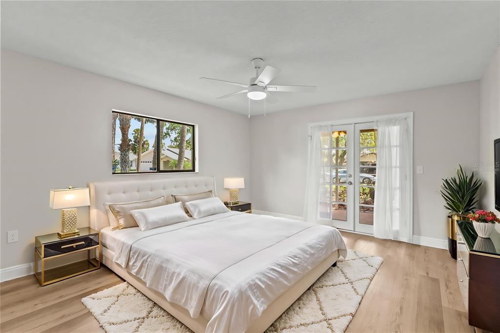 4415 Marine Parkway New Port Richey, FL 34652 - Photo 23 of 72 a bedroom with a large bed and a chandelier