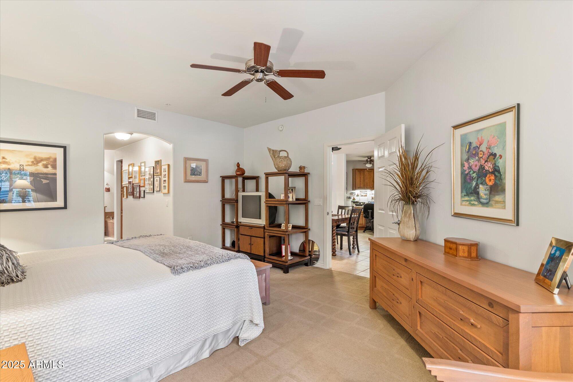 5350 East Deer Valley Drive, Unit 1238 Phoenix, AZ 85054 - Photo 13 of 29 a spacious bedroom with a bed a couch and a chandelier