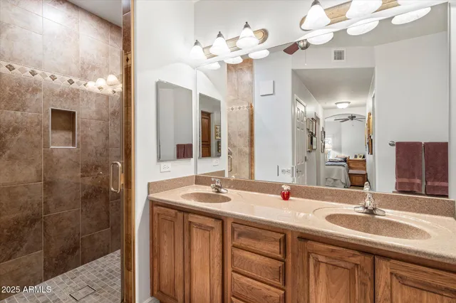 a spacious bedroom with a bed a couch and a chandelier