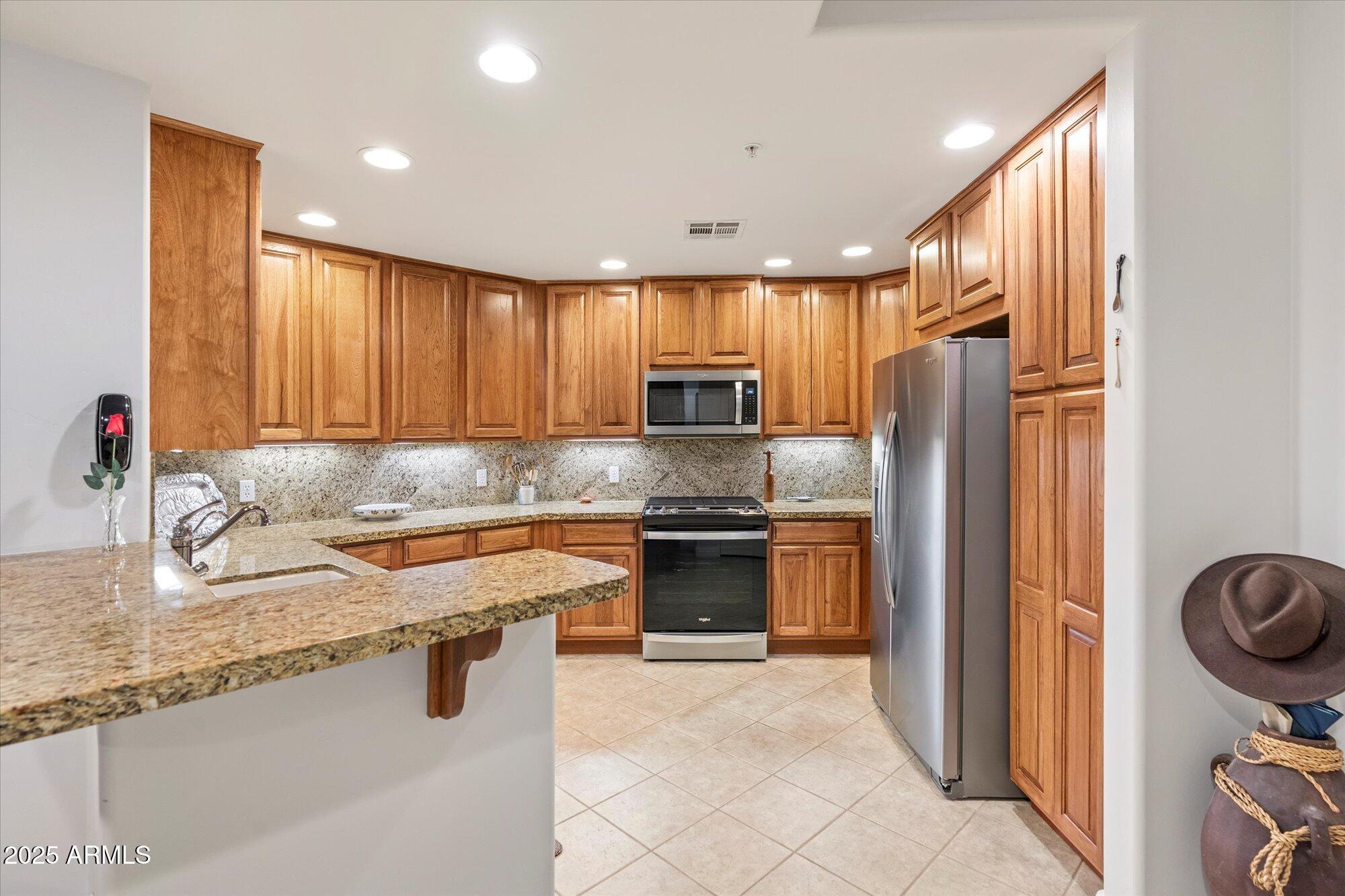 5350 East Deer Valley Drive, Unit 1238 Phoenix, AZ 85054 - Photo 3 of 29 a kitchen with stainless steel appliances granite countertop a sink stove and refrigerator