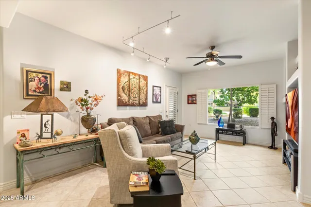 a living room with furniture a ceiling fan and a rug