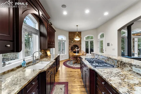 a kitchen with stainless steel appliances granite countertop a sink stove and cabinets