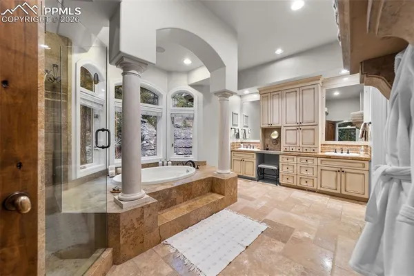 a large white kitchen with lots of counter space and stainless steel appliances