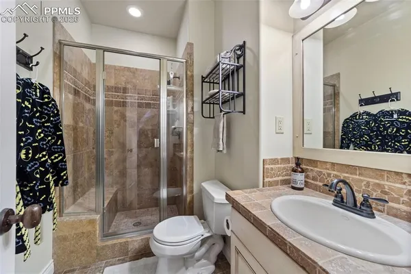 a spacious bedroom with a bed and a flat tv screen on dresser