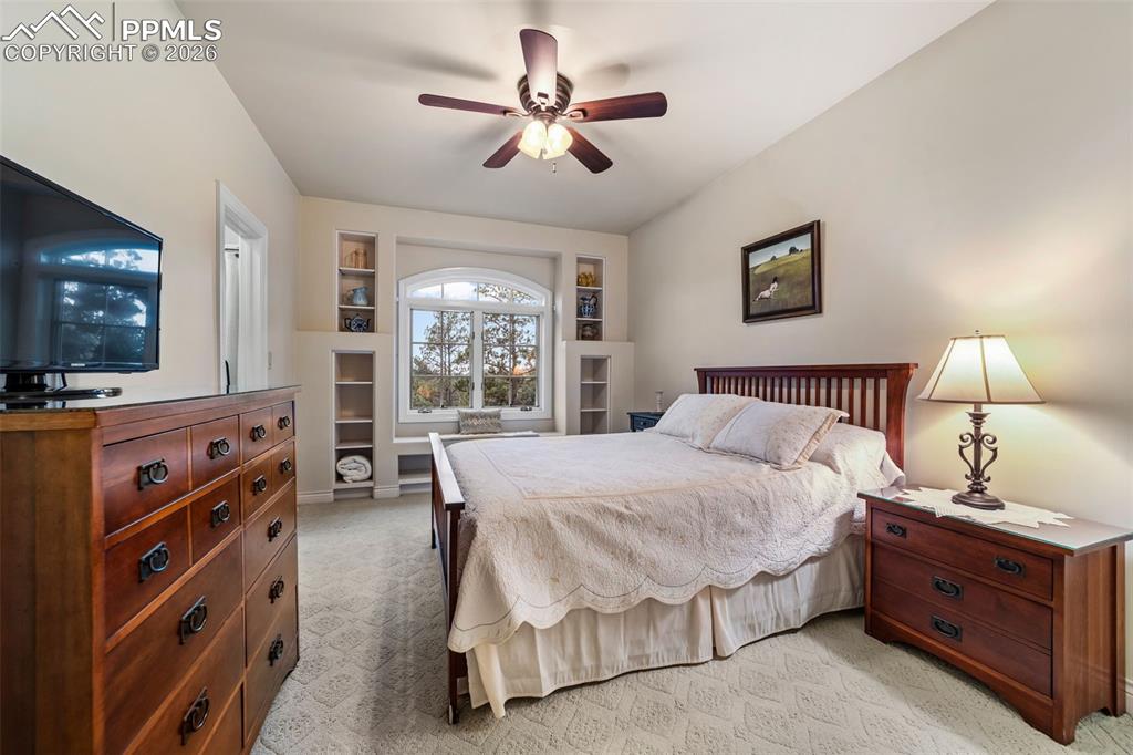 4450 Abert Ridge View Colorado Springs, CO 80908 - Photo 32 of 50 a spacious bedroom with a bed and a flat tv screen on dresser
