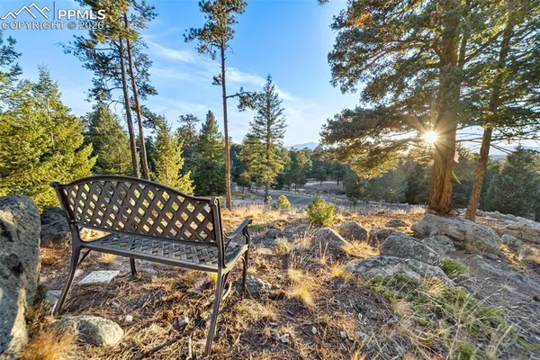 a view of a wooden chairs and iron fence
