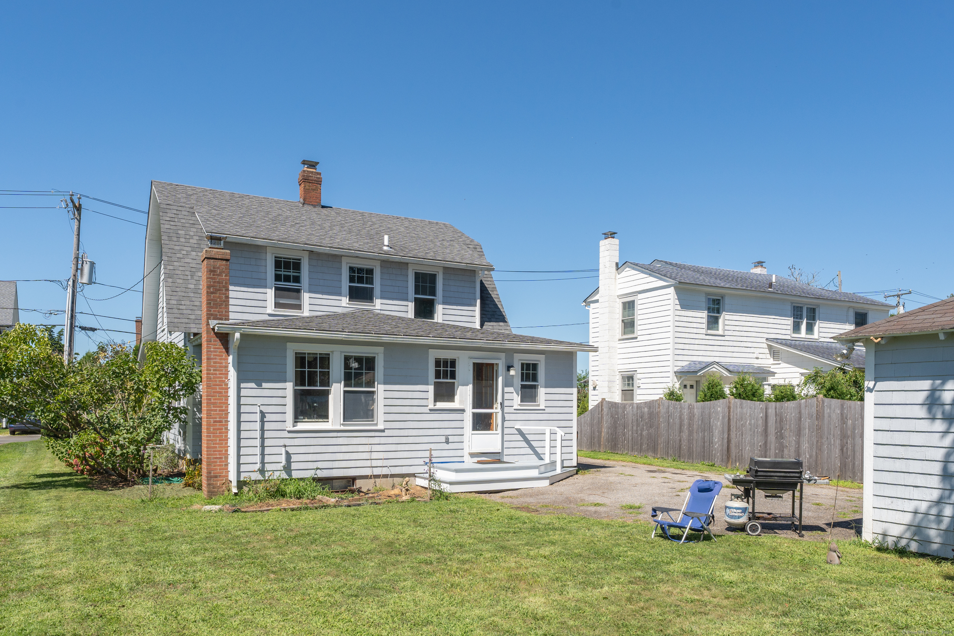 27 Ridgewood Avenue Madison, CT 06443 - Photo 20 of 31 a backyard of a house with table and chairs