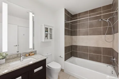 a spacious bathroom with a toilet a sink and a mirror