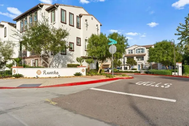 a front view of a building with palm trees