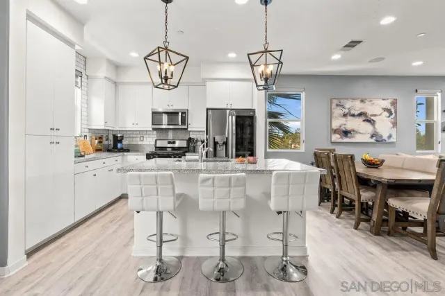 a kitchen with stainless steel appliances kitchen island granite countertop a table and chairs in it