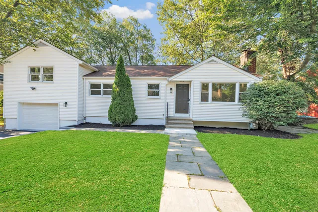 a front view of a house with a garden and yard