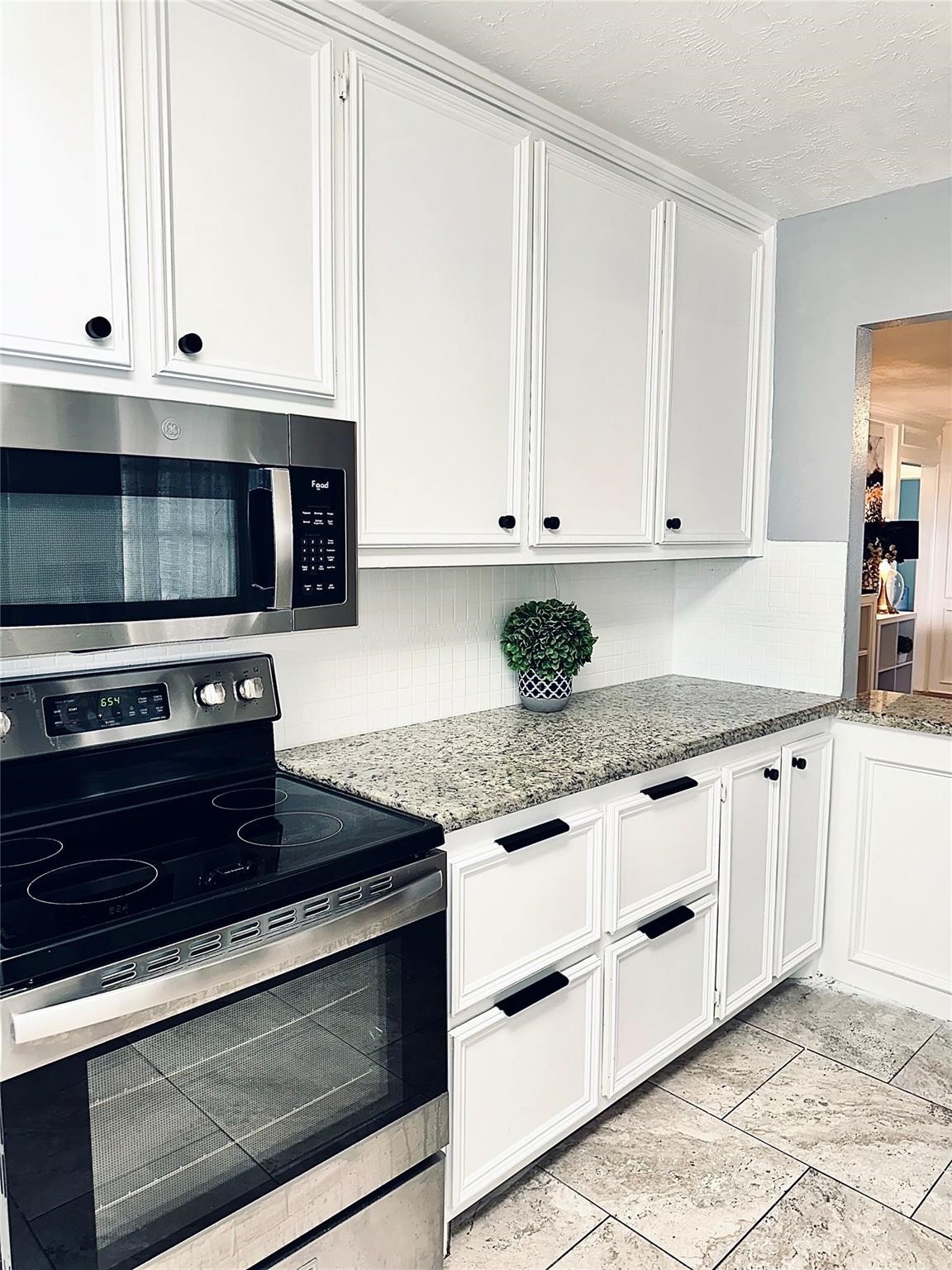 1457 Camellia Street Sweeny, TX 77480 - Photo 11 of 29 a kitchen with granite countertop white cabinets and a stove