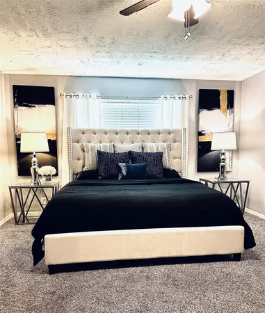 a spacious bedroom with a bed a lamp and a large window