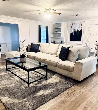 a living room with furniture a flat screen tv and kitchen view