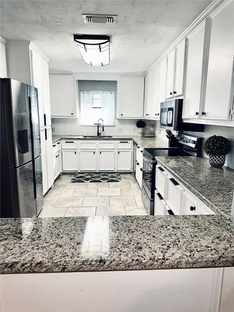 a kitchen with stainless steel appliances granite countertop a stove microwave and sink