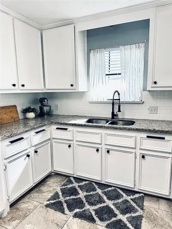 a kitchen with granite countertop a refrigerator and a sink