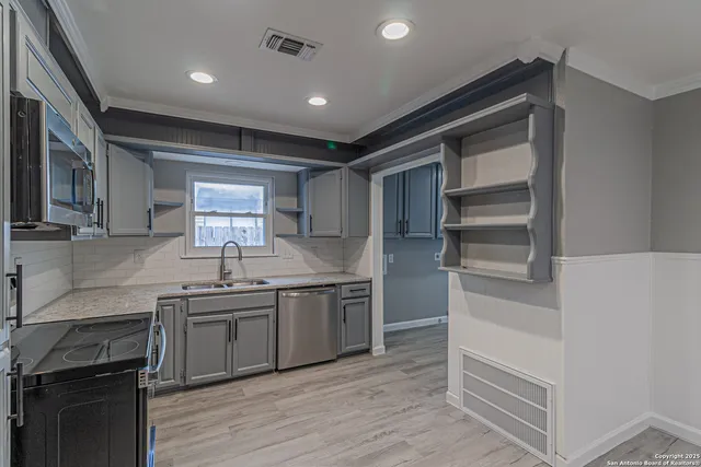 a kitchen with a sink appliances and cabinets